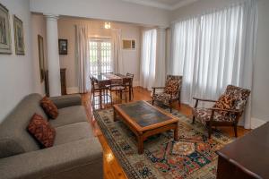 a living room with a couch and a table and chairs at Harcourt Lodge in Durban