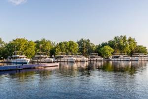 a group of boats docked at a dock on a lake at Luxury Rideau Apartments by GLOBALSTAY in Smiths Falls