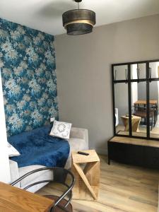 a living room with a couch and a mirror at Le Florence in Saint-Quentin