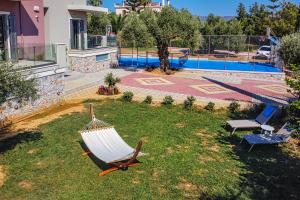 a hammock in the yard of a house with a pool at Cypress Village - Lux villa 5' from beach in Daratso