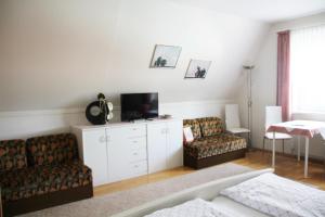 a living room with two couches and a tv at Haus Beate in Illmitz