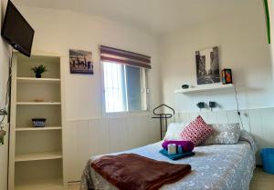 una camera con letto, finestra e televisore di Bruno´s House Apartment View a Pájara