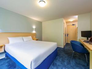 a hotel room with a large bed and a desk at go2 Dundee Camperdown Hotel free car park in Dundee