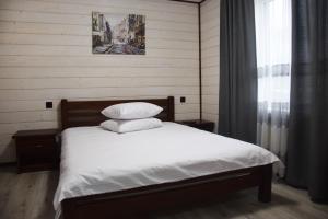 um quarto com uma cama com lençóis brancos e almofadas em Краєвид em Slavske