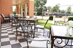 an outdoor patio with tables and chairs and flowers at JH Adams Inn, Trademark Collection by Wyndham in High Point