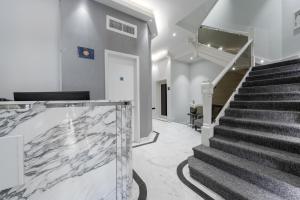 a hallway with stairs leading up to a staircase at Kensington Court by CAPITAL in London