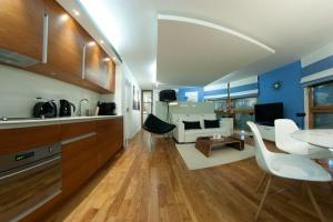 Una cocina y una sala de estar con mesa y sillas. en Nadmorski Park, en Jastarnia 16 fotos más