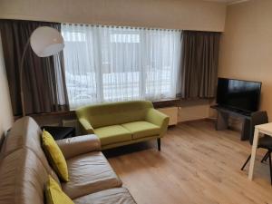 a living room with a couch and a television at Mathilda - apartments in Grobbendonk