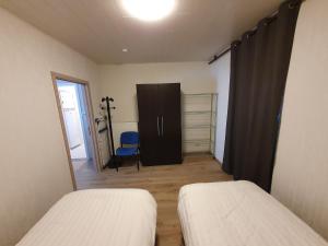 um quarto com 2 camas, uma porta e uma cadeira em Mathilda - apartments em Grobbendonk