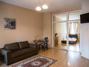 a living room with a couch and a bedroom at Amber in Liepāja