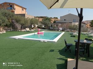 un patio trasero con una piscina con un tobogán de agua rosado en B&B Villa Kairos, en Agrigento