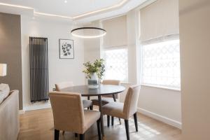 a living room with a table and chairs at Kensington Court by CAPITAL in London