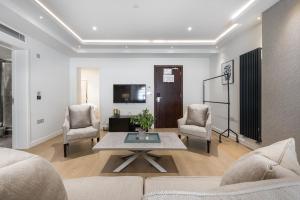 a living room filled with furniture and a tv at Kensington Court by CAPITAL in London