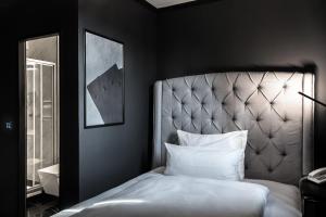 a bedroom with a bed with a headboard and a mirror at Hotel Belmont Classic in Bonn