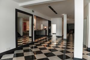 a lobby with a black and white checkered floor at Hotel Le Bois De Bruges in Bruges