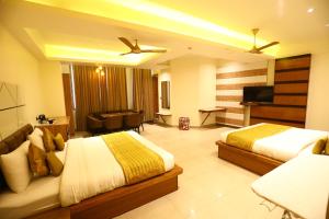 a hotel room with two beds and a flat screen tv at Hotel Grand Kailash,Kotdwara in Kotdwāra