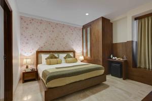a bedroom with a bed and a pink wall at Shahpura Residency in Jaipur +22 photos