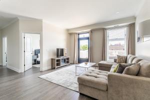 ein Wohnzimmer mit einem Sofa und einem Tisch in der Unterkunft Luxury Rideau Apartments by GLOBALSTAY in Smiths Falls