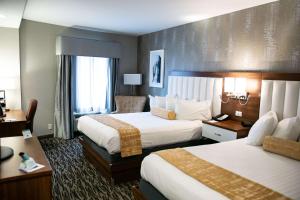 a hotel room with two beds and a desk at Best Western On The Avenue in Buffalo