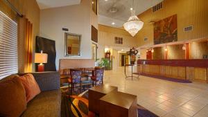 a living room with a couch and a bar at Best Western Plus Tulsa Woodland Hills Hotel and Suites in Tulsa