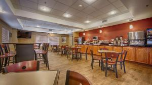 a restaurant with tables and chairs and a bar at Best Western Plus Tulsa Woodland Hills Hotel and Suites in Tulsa