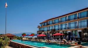un hotel con piscina di fronte a un edificio di Chateau Mere a Telavi