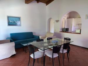 a living room with a glass table and chairs at Villa Venere in Stintino