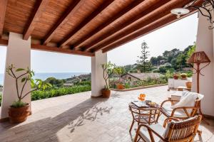 patio ze stołem i krzesłami oraz dużym oknem w obiekcie Villa Melinda - Charme Holidays w mieście Licata