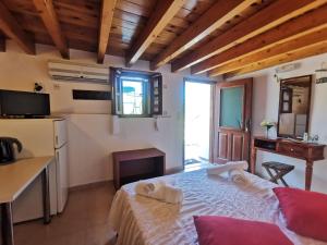 a bedroom with a bed and a kitchen with a table at Kalypso apartment in Halki