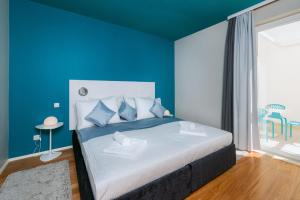 a blue bedroom with a large bed with blue walls at Apartments Villa Azzurra Bol in Bol