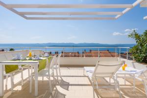 a balcony with a table and chairs and the ocean at Apartments Villa Azzurra Bol in Bol