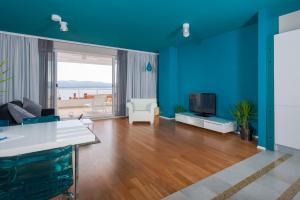a living room with blue walls and a television at Apartments Villa Azzurra Bol in Bol