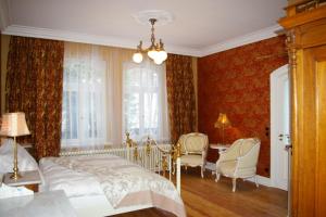 1 dormitorio con 1 cama, mesa y sillas en Historische Pension Villa Uhlenhorst, en Wernigerode