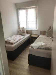 ein kleines Schlafzimmer mit 2 Betten und einem Fenster in der Unterkunft Pension Kaiser in Haldensleben