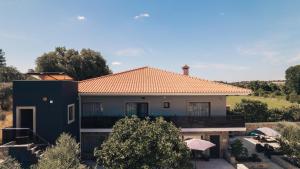 uma casa com um telhado laranja e uma casa em Arca dos Animais - Farming & SPA em Castelo Branco
