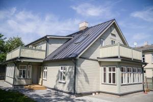 a white house with a gambrel roof at Haapsalu Guesthouse in Haapsalu