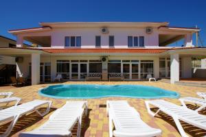 a villa with a swimming pool and lounge chairs at Villa na More.Club in Arkhipo-Osipovka