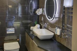 a bathroom with a sink, toilet and mirror at The Eccleston Hotel; BW Signature Collection in Saint Helens