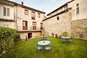 un patio con mesas y sillas en Hotel O Portelo Rural, en Allariz