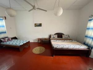 a room with two beds and a bench in it at Zava House Stone town in Zanzibar City