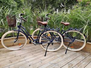 dos bicicletas estacionadas una al lado de la otra en una terraza de madera en Gîtes L'Ancienne Ecurie - L'Ancien Atelier, en Saint-Quentin-en-Tourmont