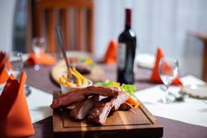 talerz mięsa i warzyw na stole z butelką wina w obiekcie The Ad Lib Executive lodge w mieście Lilongwe