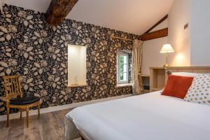 een slaapkamer met een bed en een muur bedekt met bloemenbehang bij LE COTTAGE DU PARC in Chambéon +44 foto's