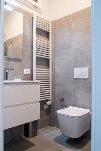 uma casa de banho com um WC, um lavatório e um espelho. em Marconi 442 em Sanremo
