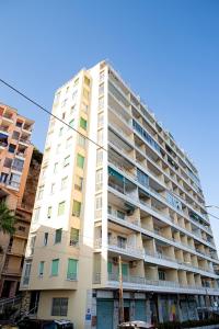 un edificio de apartamentos alto y blanco con balcones en Marconi 442, en San Remo
