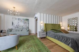 a bedroom with a bed and a couch and a tub at De Merin Boutique Hotel Straden in Straden