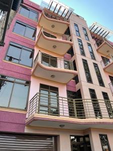 un edificio alto con balcones a un lado. en Jaffa Suites, en Kampala