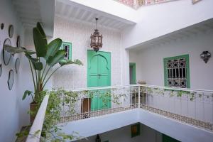 un couloir avec une porte verte et une plante dans l'établissement Riad Le Limoun and Spa, à Marrakech