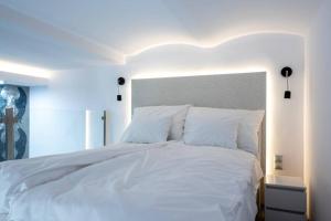a large white bed with white sheets and pillows at Luxus a város felett in Szombathely