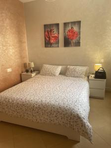 sypialnia z łóżkiem i dwoma obrazami na ścianie w obiekcie Ifrane Chalet w mieście Ifrane